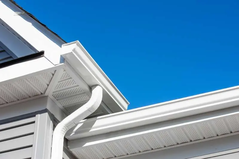 Close-up of a modern seamless gutter installation on a home, designed for efficient water runoff.